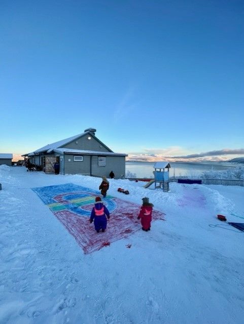 Barn som ser p&aring; det samiske flagget som er malt i sn&oslash;en